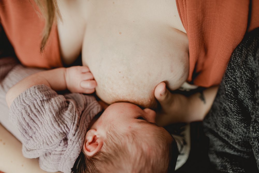 Mom breastfeeding newborn baby girl