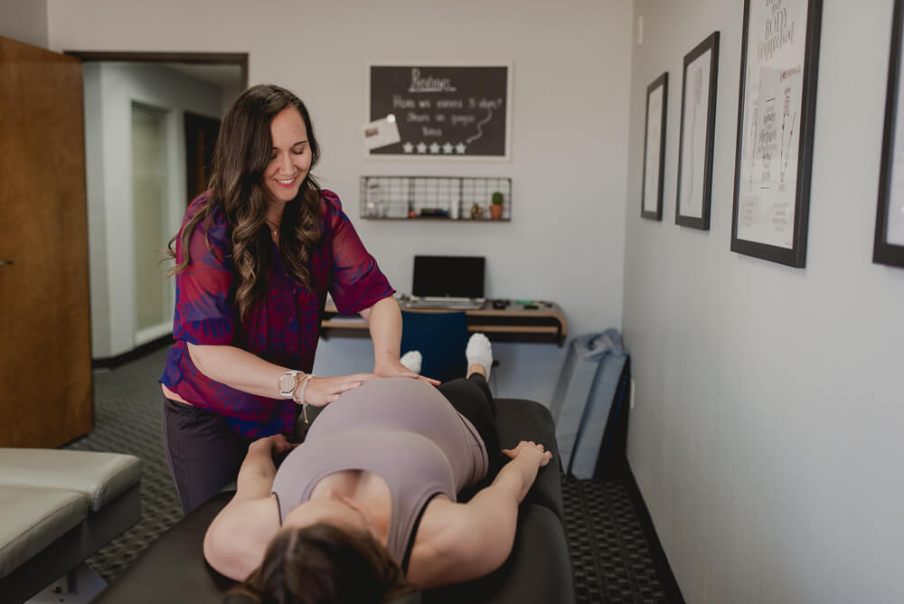 Dr. Ashley Deboer from Kokua Wellness giving a pregnant woman a chiropractic adjustment