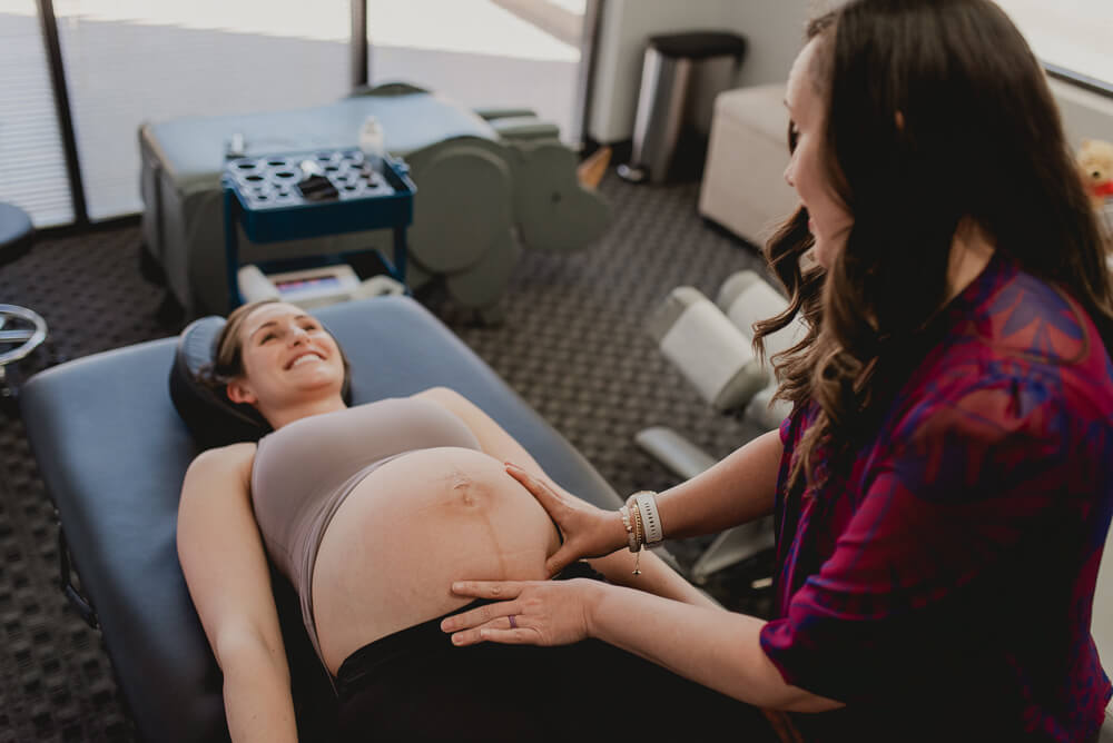 female chiropractor examining a pregnant woman's pelvis