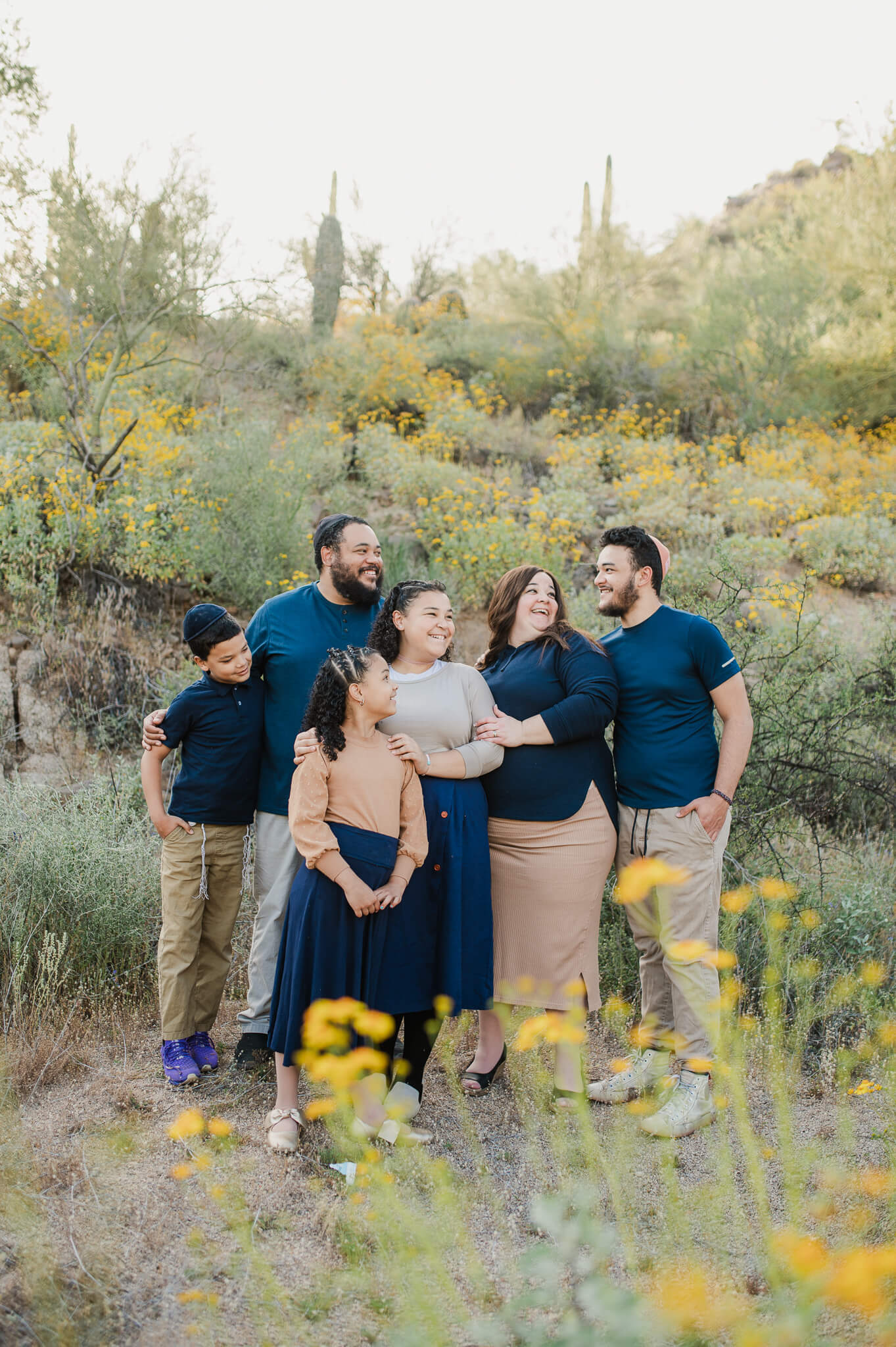 family of six smiling together standing in a field of wildflowers in phoenix