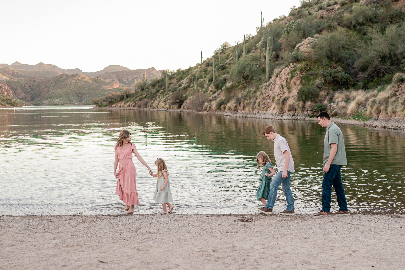 family of five walking alongside the lake's edge at Butcher Jones - one of the best places for family photos in Phoenix