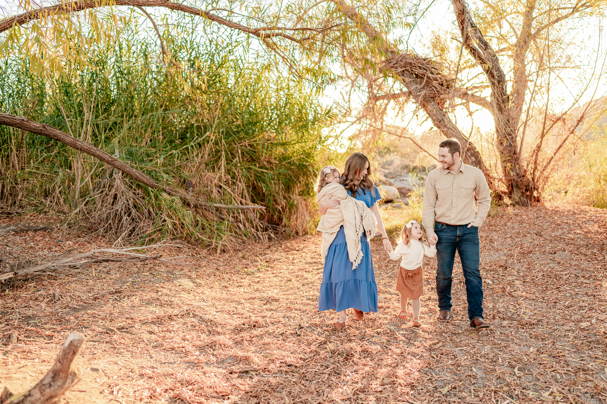 family of four walking among the trees near at one of the best places for family photos in Phoenix 