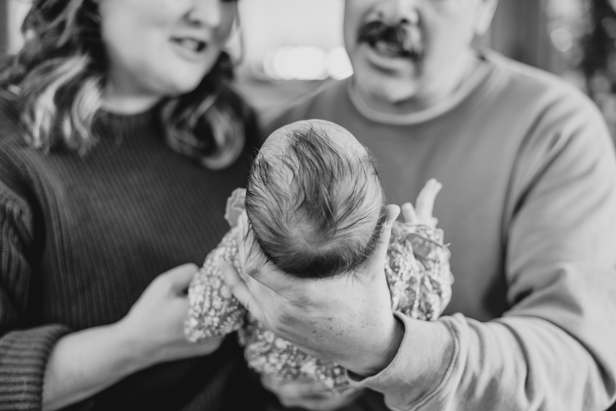 Details of a newborn baby's hair while laying in dad's hands after visiting strolleria scottsdale